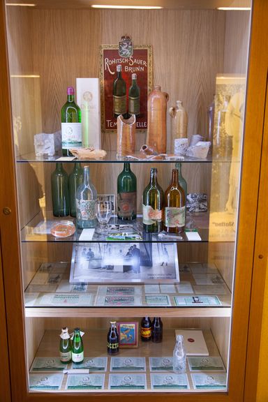 A display cabinet with healing mineral water bottles (the oldest ones made of clay) and old bottle labels. Folk Museum Rogaška Slatina at Ana's Mansion, 2012