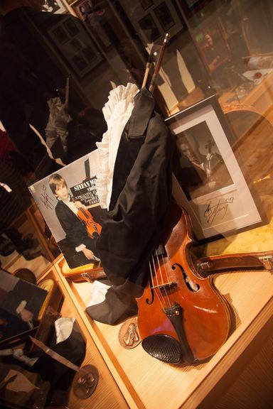 An autograph of Stefan Milenković, a Serbian child prodigy and famous concert violinist, his first violin and a frock coat. Part of the Philographic Collection of the Folk Museum Rogaška Slatina at Ana's Mansion, 2012